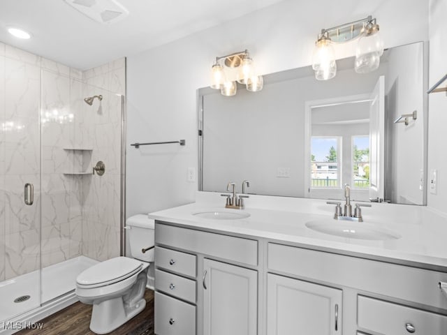 bathroom with hardwood / wood-style floors, vanity, toilet, and a shower with door