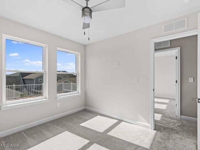 unfurnished room featuring ceiling fan and carpet