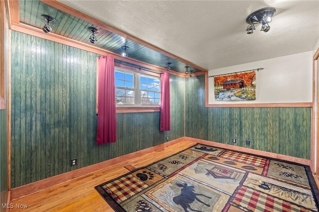 unfurnished room with hardwood / wood-style floors and a textured ceiling