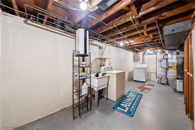 basement featuring independent washer and dryer, sink, and water heater