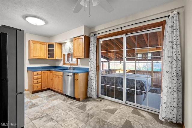 kitchen featuring appliances with stainless steel finishes, a textured ceiling, ceiling fan, and sink