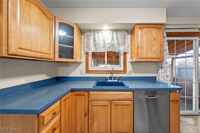 kitchen with stainless steel dishwasher, light tile patterned floors, and sink