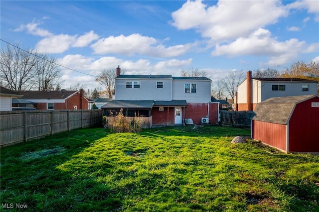 back of house featuring a yard and a storage unit