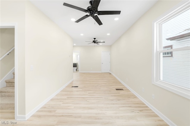 corridor featuring stairs, baseboards, light wood-style flooring, and recessed lighting