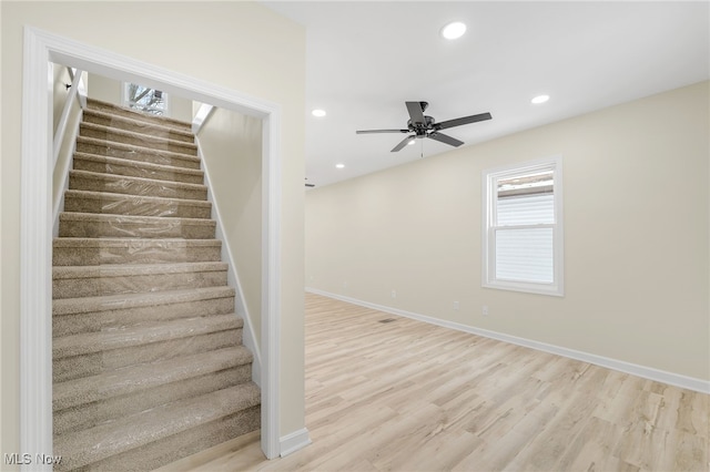 staircase with a ceiling fan, recessed lighting, baseboards, and wood finished floors