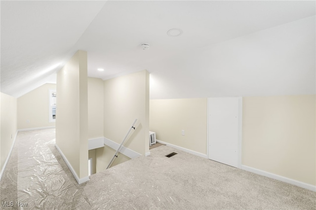 bonus room featuring lofted ceiling, light carpet, visible vents, and baseboards