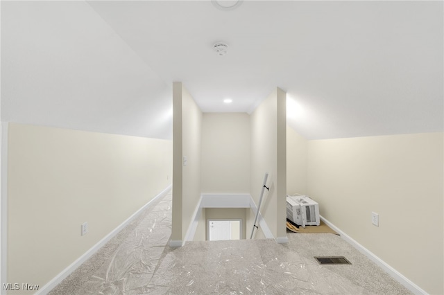 corridor featuring lofted ceiling and light carpet