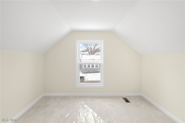 bonus room featuring lofted ceiling and light carpet