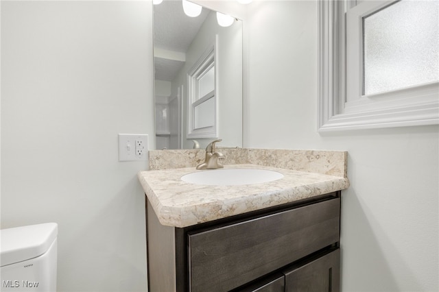 half bath featuring toilet and vanity