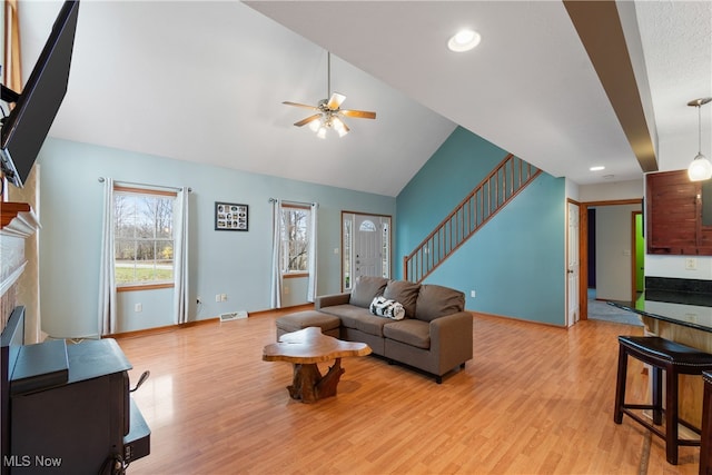 living room with ceiling fan, high vaulted ceiling, and light hardwood / wood-style flooring