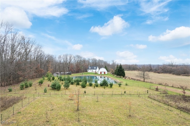 view of yard featuring a rural view, an outdoor structure, and a water view