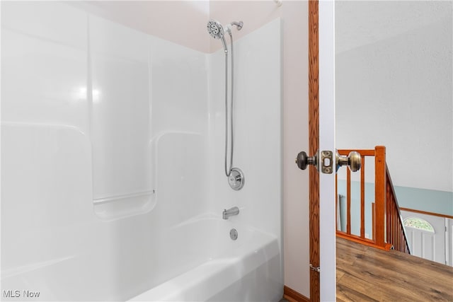 bathroom featuring hardwood / wood-style floors and  shower combination