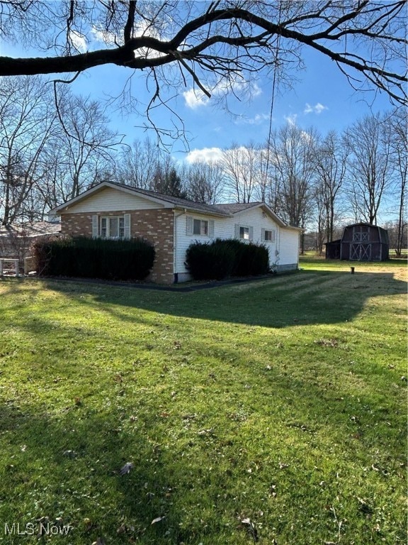 view of home's exterior with a storage shed and a lawn