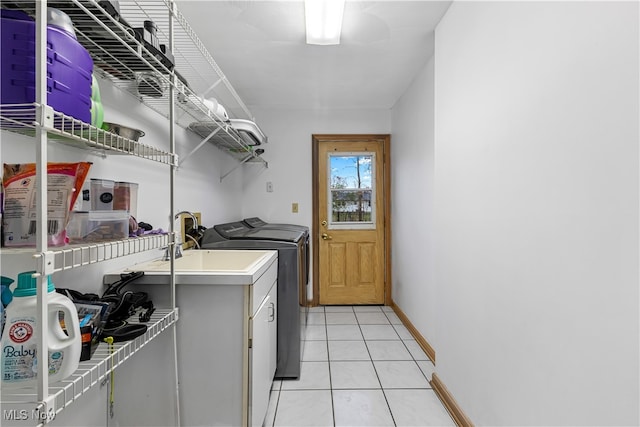 laundry area featuring cabinets, light tile patterned floors, and separate washer and dryer