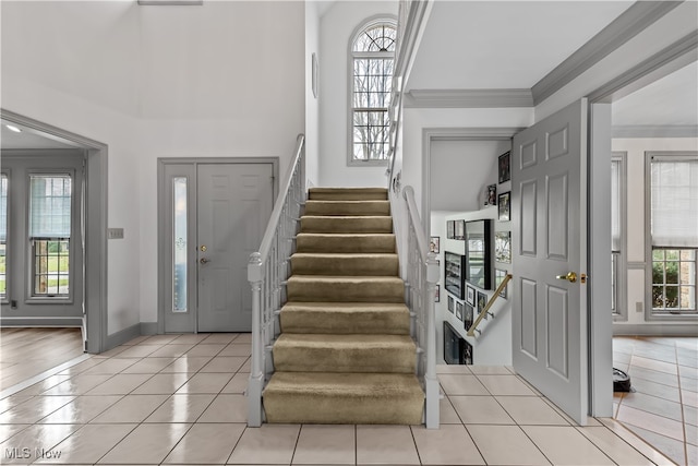 foyer entrance featuring crown molding and light tile patterned floors