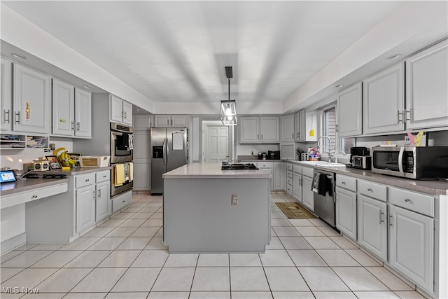 kitchen with pendant lighting, gray cabinetry, a center island, sink, and stainless steel appliances