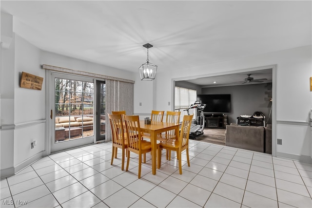 dining room with light tile patterned flooring and ceiling fan with notable chandelier