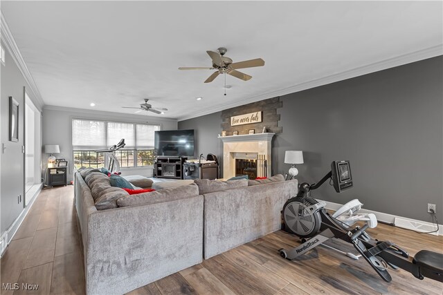 living room featuring a fireplace, ceiling fan, hardwood / wood-style floors, and ornamental molding