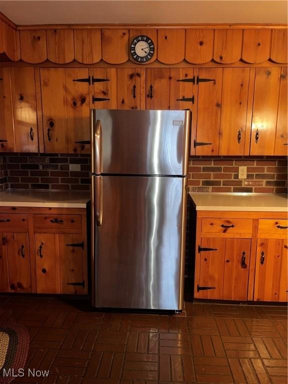 kitchen featuring stainless steel fridge and tasteful backsplash