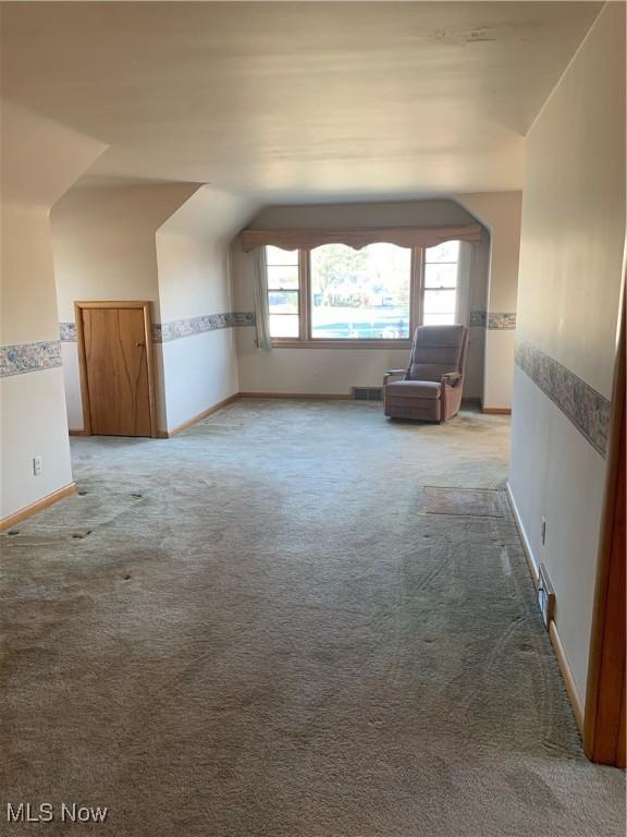 bonus room featuring lofted ceiling and carpet floors