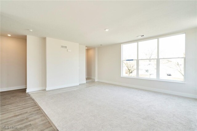 spare room featuring baseboards, light wood-style floors, and recessed lighting