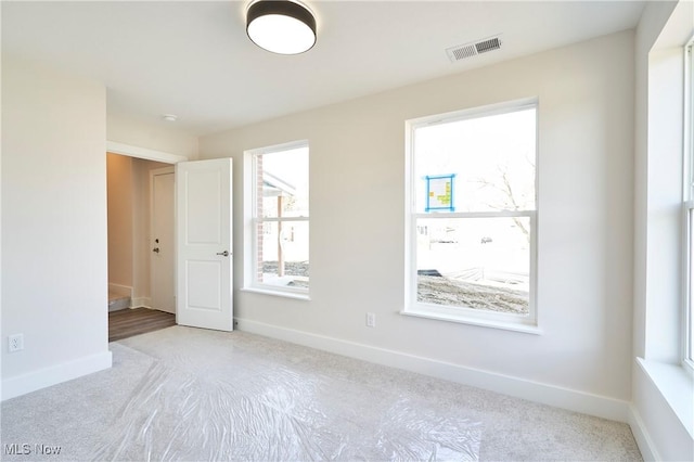 carpeted spare room with baseboards
