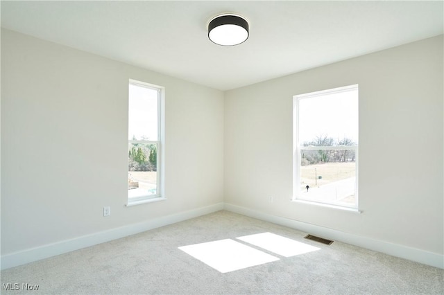 carpeted empty room with baseboards