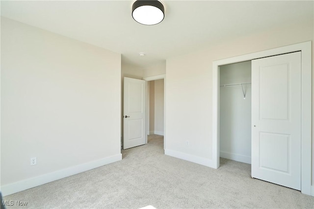 unfurnished bedroom with carpet, baseboards, and a closet