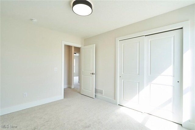 unfurnished bedroom with carpet, baseboards, and a closet
