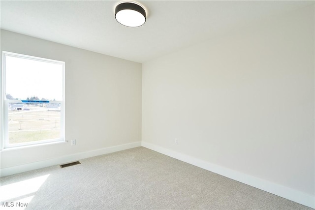 carpeted empty room with baseboards
