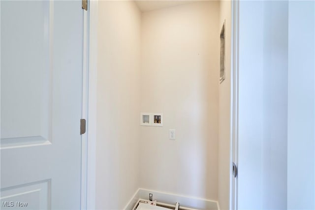 washroom with hookup for a washing machine and baseboards