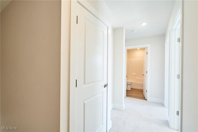hallway with light carpet, baseboards, and recessed lighting