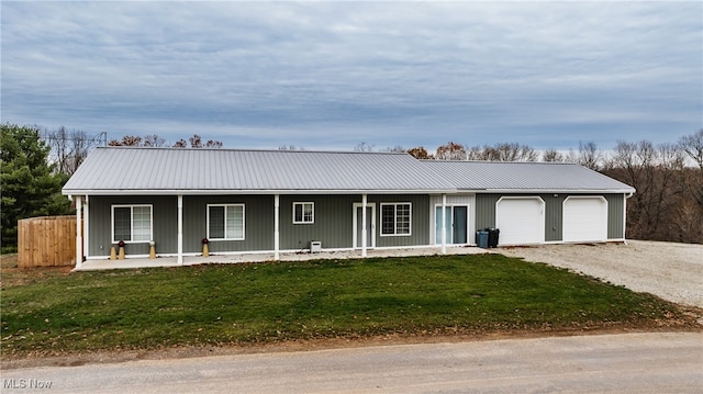 ranch-style home with a front lawn, covered porch, and a garage