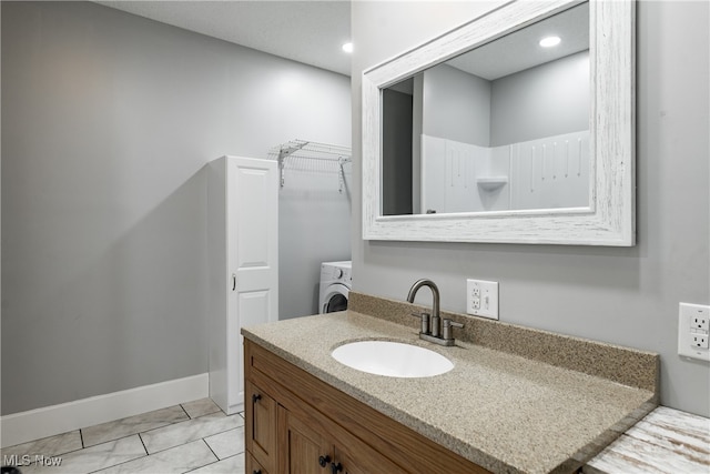 bathroom featuring tile patterned floors, vanity, and washer / clothes dryer