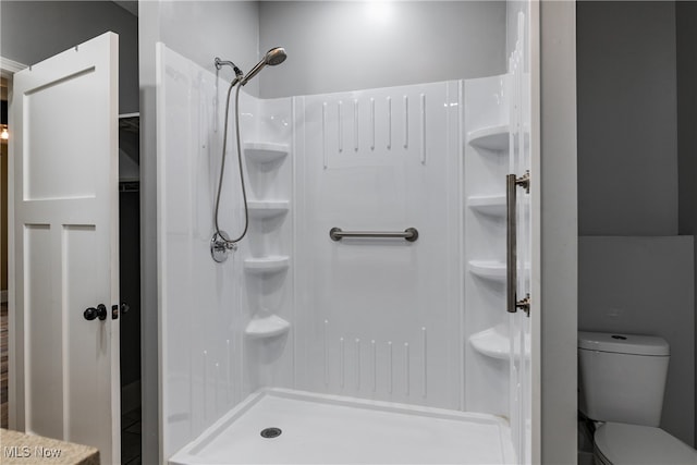 bathroom featuring toilet and walk in shower