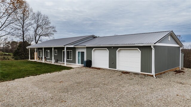 view of front of property featuring a front lawn, covered porch, and a garage