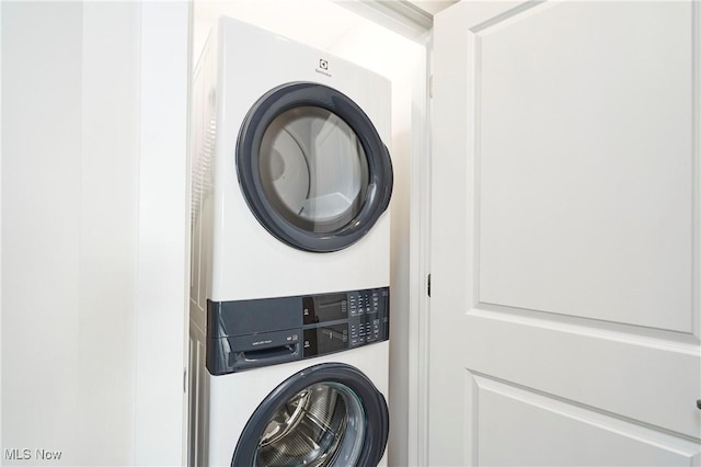 laundry room with mail area, stacked washer and clothes dryer, and laundry area