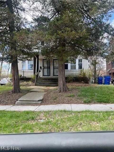 view of property hidden behind natural elements featuring a porch