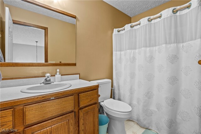 bathroom with vanity, a textured ceiling, and toilet