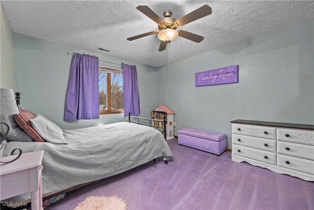 bedroom with ceiling fan, carpet floors, and a textured ceiling