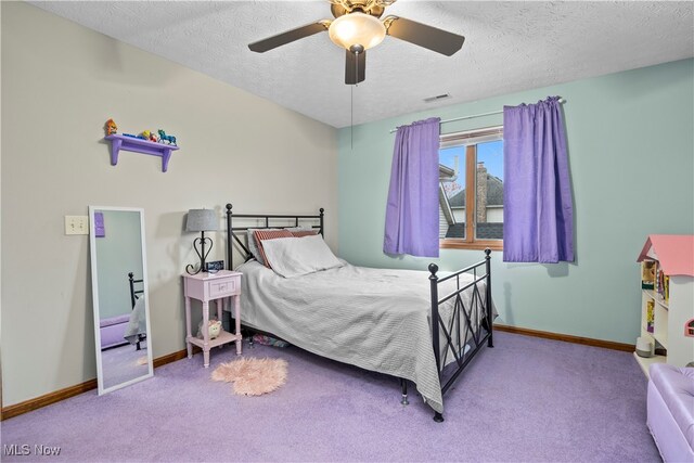 carpeted bedroom with ceiling fan and a textured ceiling