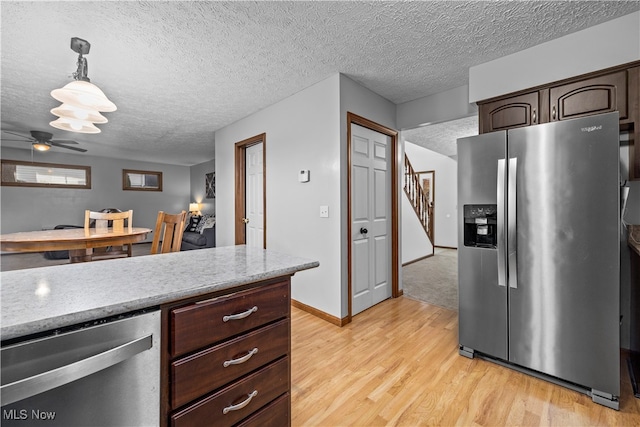 kitchen with ceiling fan, a textured ceiling, dark brown cabinets, appliances with stainless steel finishes, and light wood-type flooring