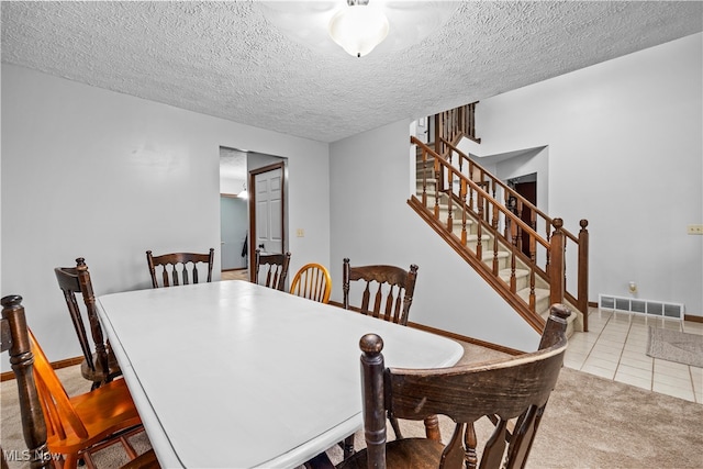 carpeted dining room featuring a textured ceiling