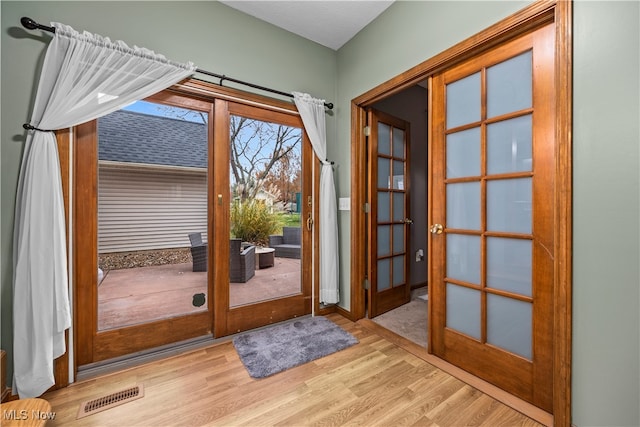 doorway to outside featuring french doors and light hardwood / wood-style floors