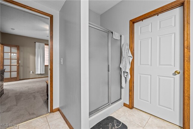 bathroom with tile patterned floors and an enclosed shower