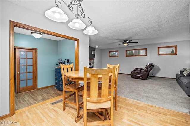 dining area featuring ceiling fan, a textured ceiling, and light hardwood / wood-style flooring