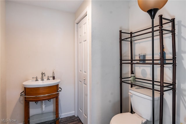 bathroom with hardwood / wood-style flooring, toilet, and sink