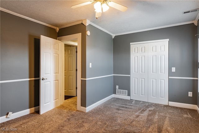 unfurnished bedroom featuring carpet, a textured ceiling, a closet, and ceiling fan