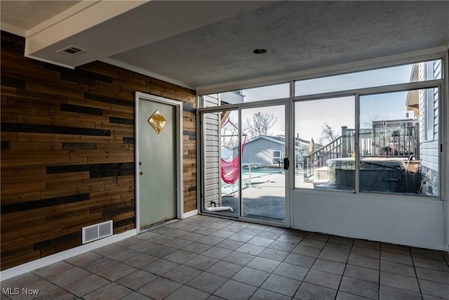 interior space featuring tile patterned floors, wood walls, and a textured ceiling