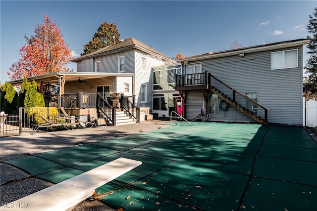 back of property with a patio area, ceiling fan, and a covered pool